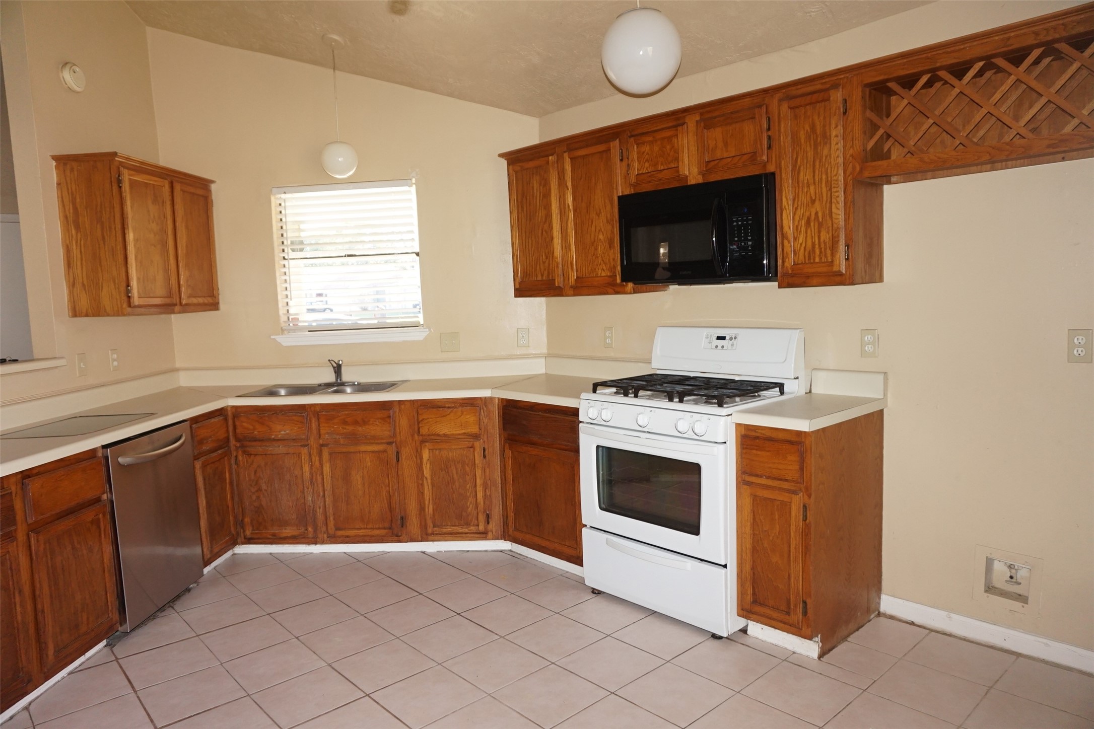 6023 Woodmancote Drive Humble, TX 77346 - Photo 4 of 12 a kitchen with stainless steel appliances a stove microwave and sink