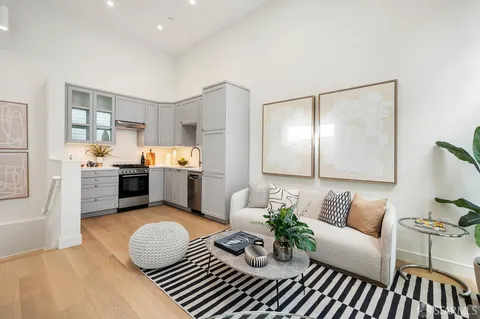 a living room with furniture and kitchen view