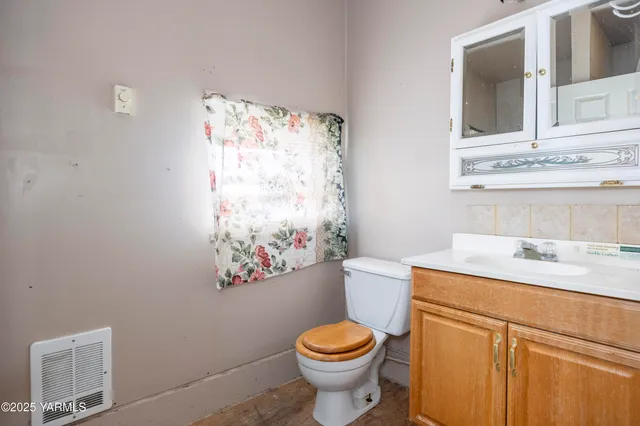a bathroom with a granite countertop toilet sink and mirror