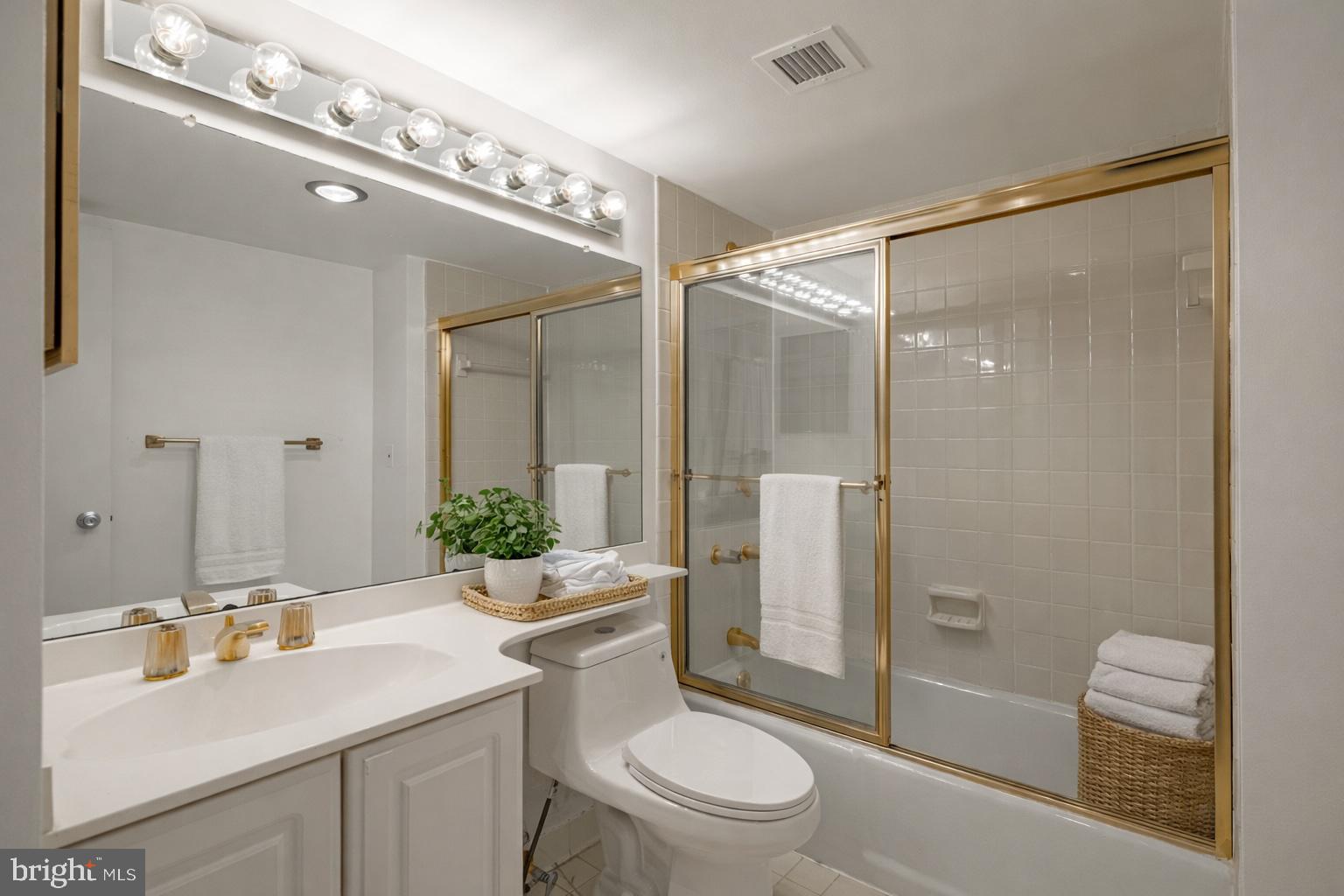 1101 South Arlington Ridge Road, Unit 704 Arlington, VA 22202 - Photo 40 of 70 a bathroom with a sink a toilet a mirror and shower