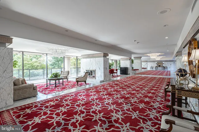 a view of a swimming pool with a lawn chairs and a large tree