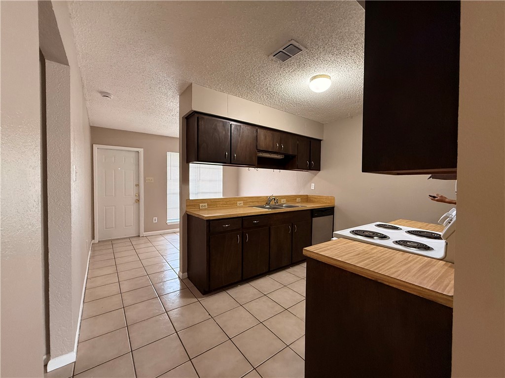 5018 Wingfoot Lane, Unit A Corpus Christi, TX 78413 - Photo 9 of 13 a kitchen with a sink a stove and cabinets