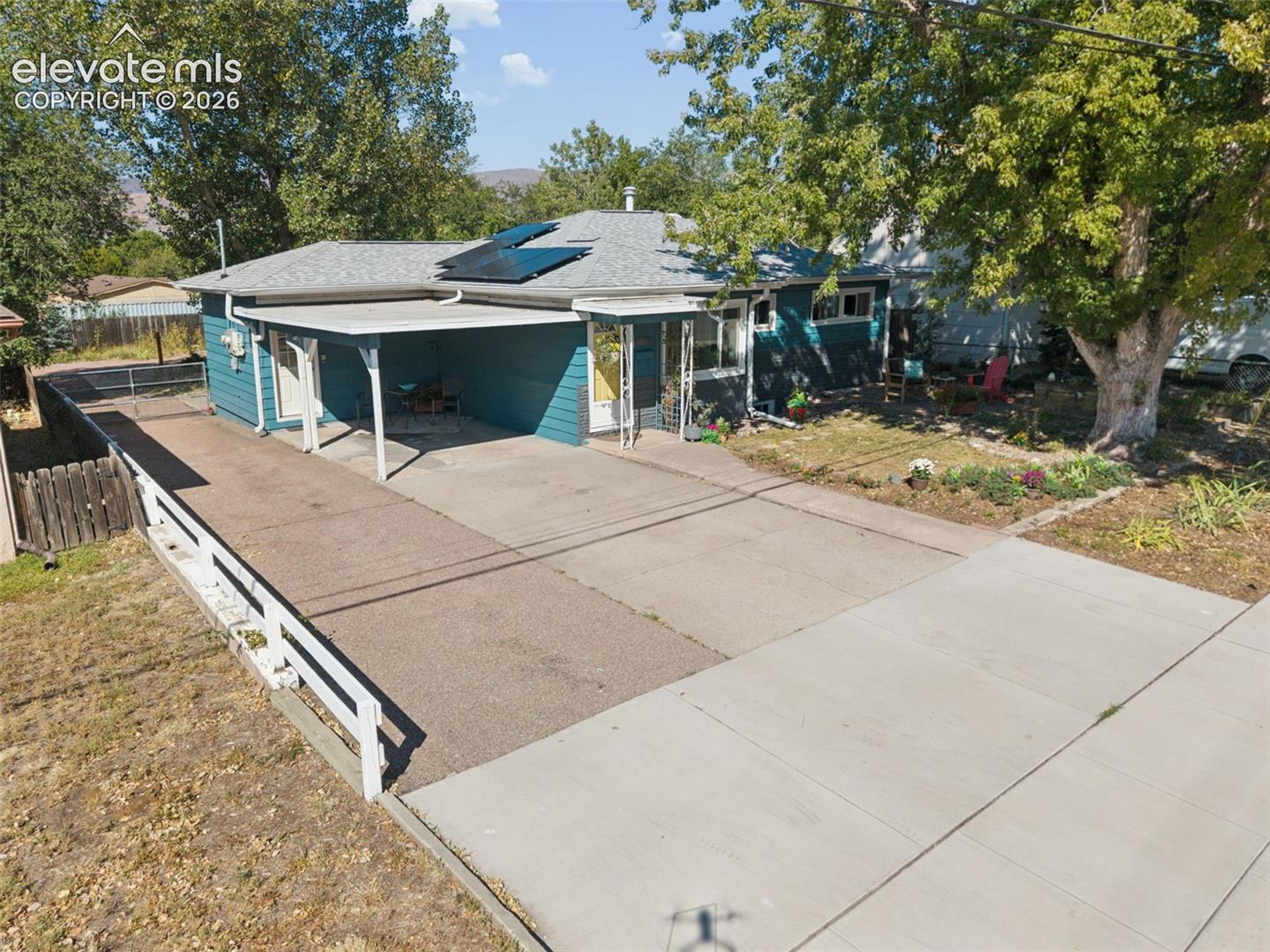 Single-story residence with a covered carport, solar panels, and a concrete driveway