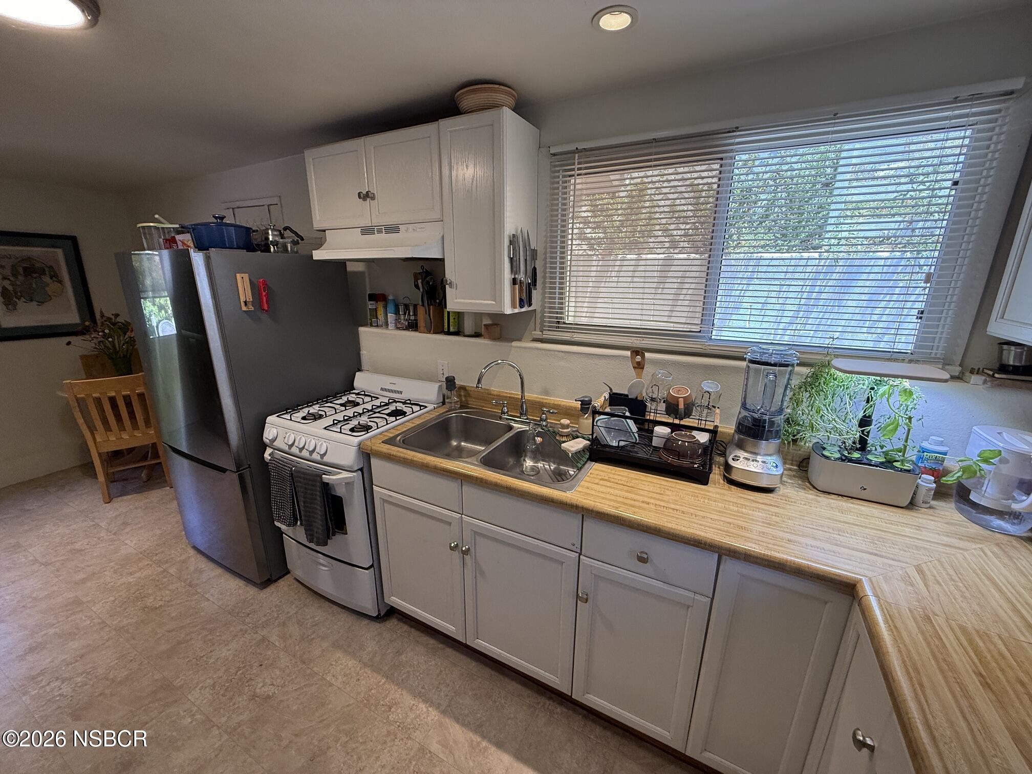561 Alisal Road Solvang, CA 93463 - Photo 48 of 53 a kitchen with stainless steel appliances granite countertop a sink stove and refrigerator