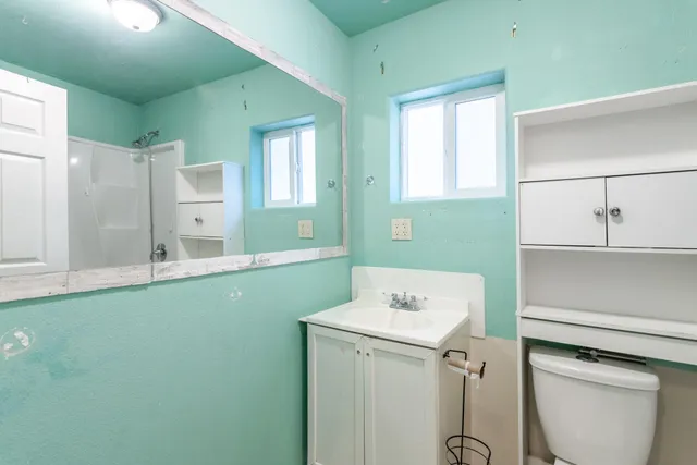 a bathroom with a sink toilet and mirror