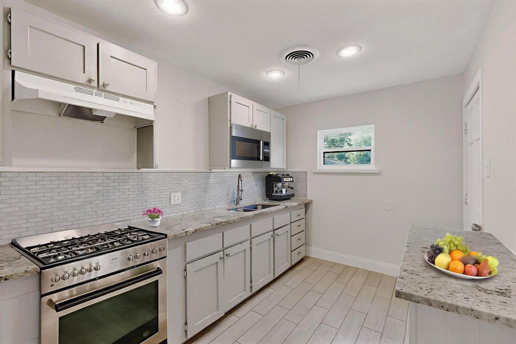 1609 Biggs Terrace Arlington, TX 76010 - Photo 2 of 18 a kitchen with stainless steel appliances granite countertop a stove a sink and a microwave