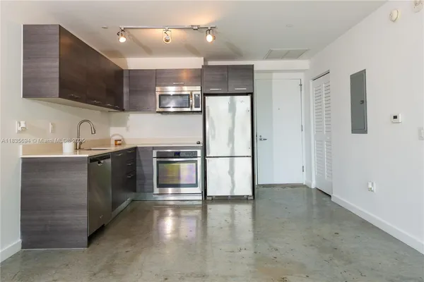 a kitchen with stainless steel appliances a refrigerator sink and microwave