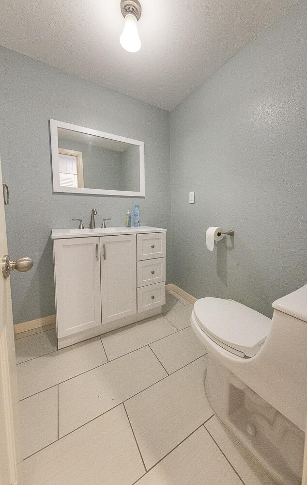 5104 19th Street Lubbock, TX 79407 - Photo 19 of 64 a white toilet sitting next to a bathroom sink