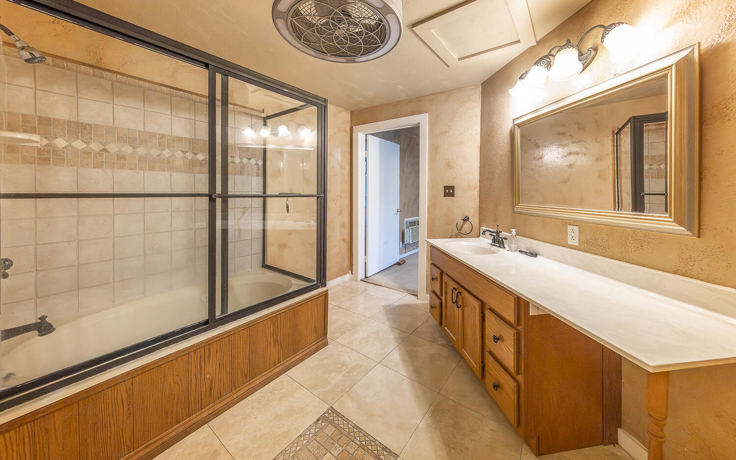 5104 19th Street Lubbock, TX 79407 - Photo 30 of 64 a spacious bathroom with a granite countertop sink a large mirror and a bathtub