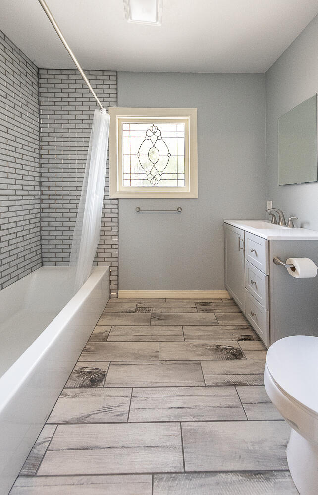5104 19th Street Lubbock, TX 79407 - Photo 31 of 64 a bathroom with a sink a toilet and bathtub