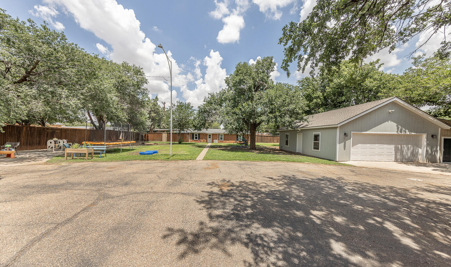 5104 19th Street Lubbock, TX 79407 - Photo 50 of 64 a view of a house with a yard and a large tree