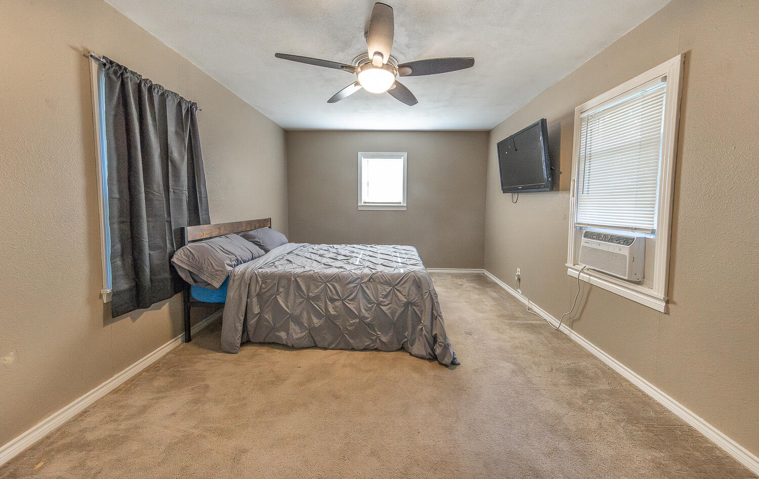 5104 19th Street Lubbock, TX 79407 - Photo 63 of 64 a bedroom with a bed and a chandelier