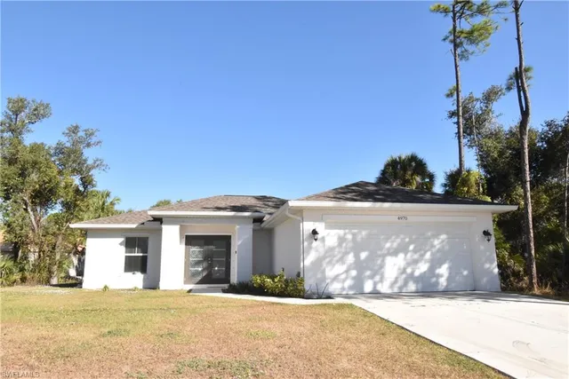 a front view of a house with a garden and yard