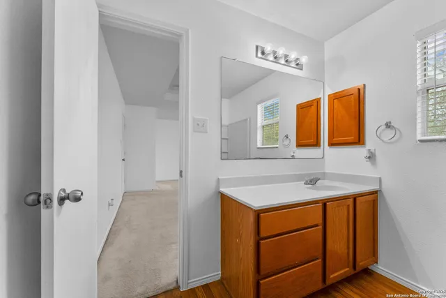 a bathroom with a sink a light fixture and a mirror