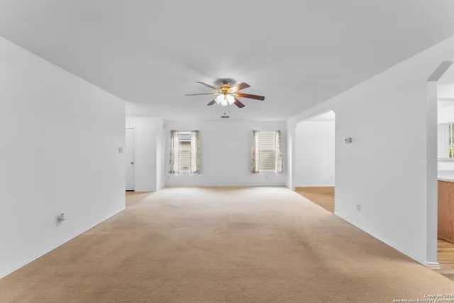 a view of a livingroom with a ceiling fan and window