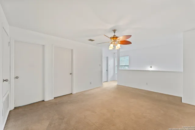 a view of a room with a ceiling fan and window