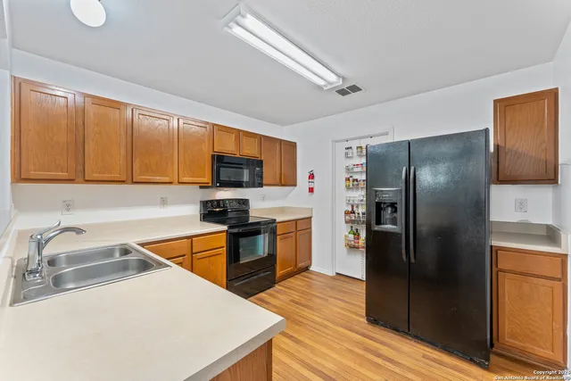 a kitchen with stainless steel appliances granite countertop a refrigerator stove top oven a sink and dishwasher