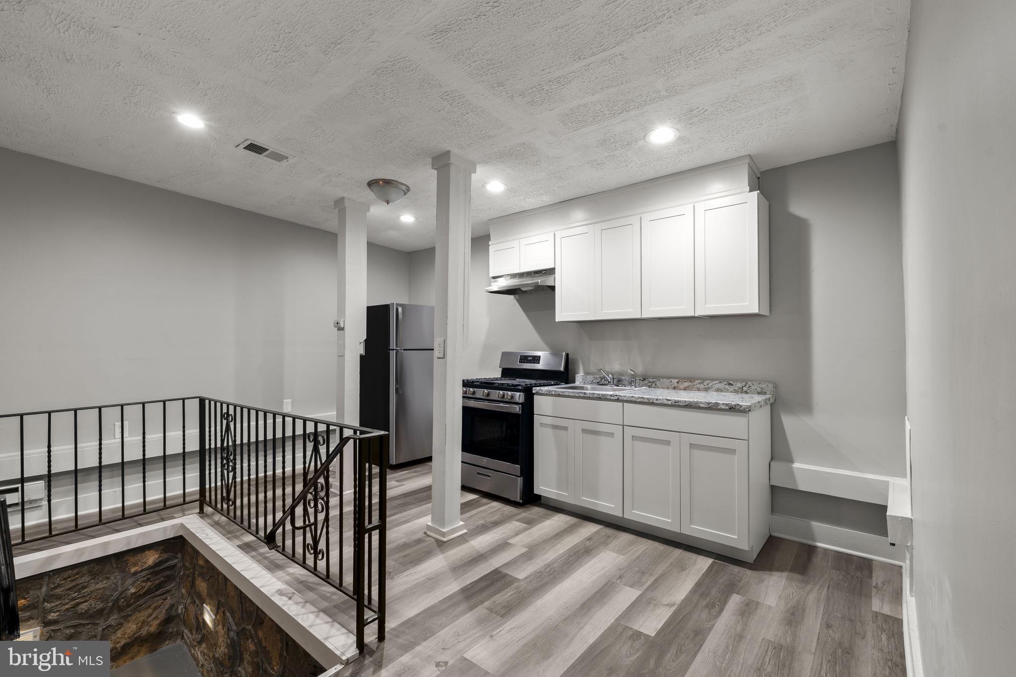 4630 Chester Avenue Philadelphia, PA 19143 - Photo 11 of 46 a kitchen with granite countertop white cabinets and stainless steel appliances