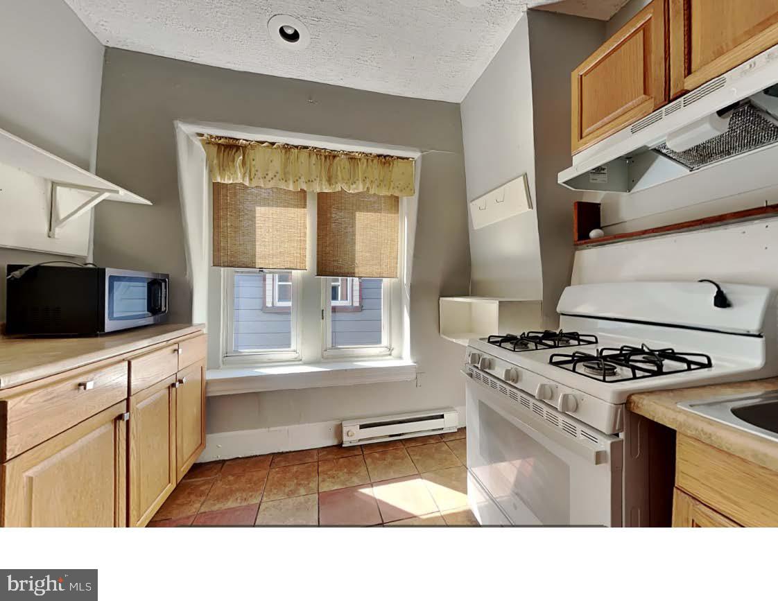 4630 Chester Avenue Philadelphia, PA 19143 - Photo 42 of 46 a kitchen with appliances cabinets and a sink