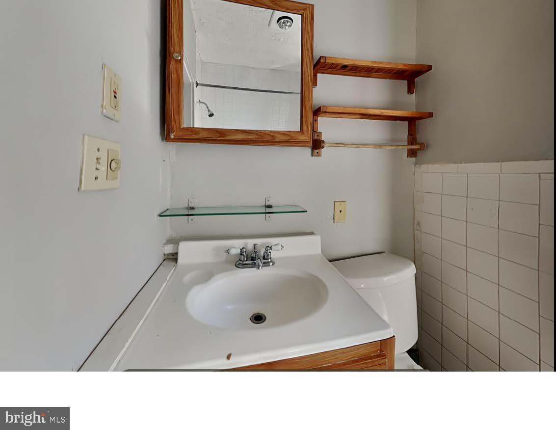 4630 Chester Avenue Philadelphia, PA 19143 - Photo 43 of 46 a bathroom with a sink mirror and vanity