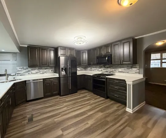 a kitchen with stainless steel appliances kitchen island granite countertop wooden cabinets microwave and stove