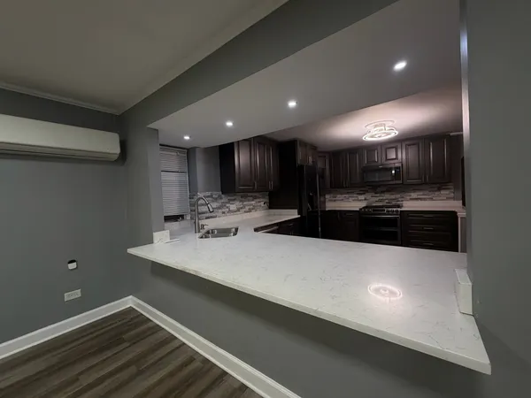 a large kitchen with kitchen island a sink stainless steel appliances and cabinets