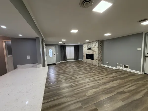 a view of an empty room with wooden floor