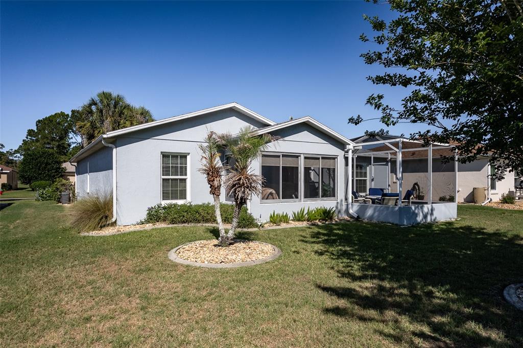 15143 Southwest 14th Avenue Road Ocala, FL 34473 - Photo 39 of 53 a front view of a house with a yard table and chairs