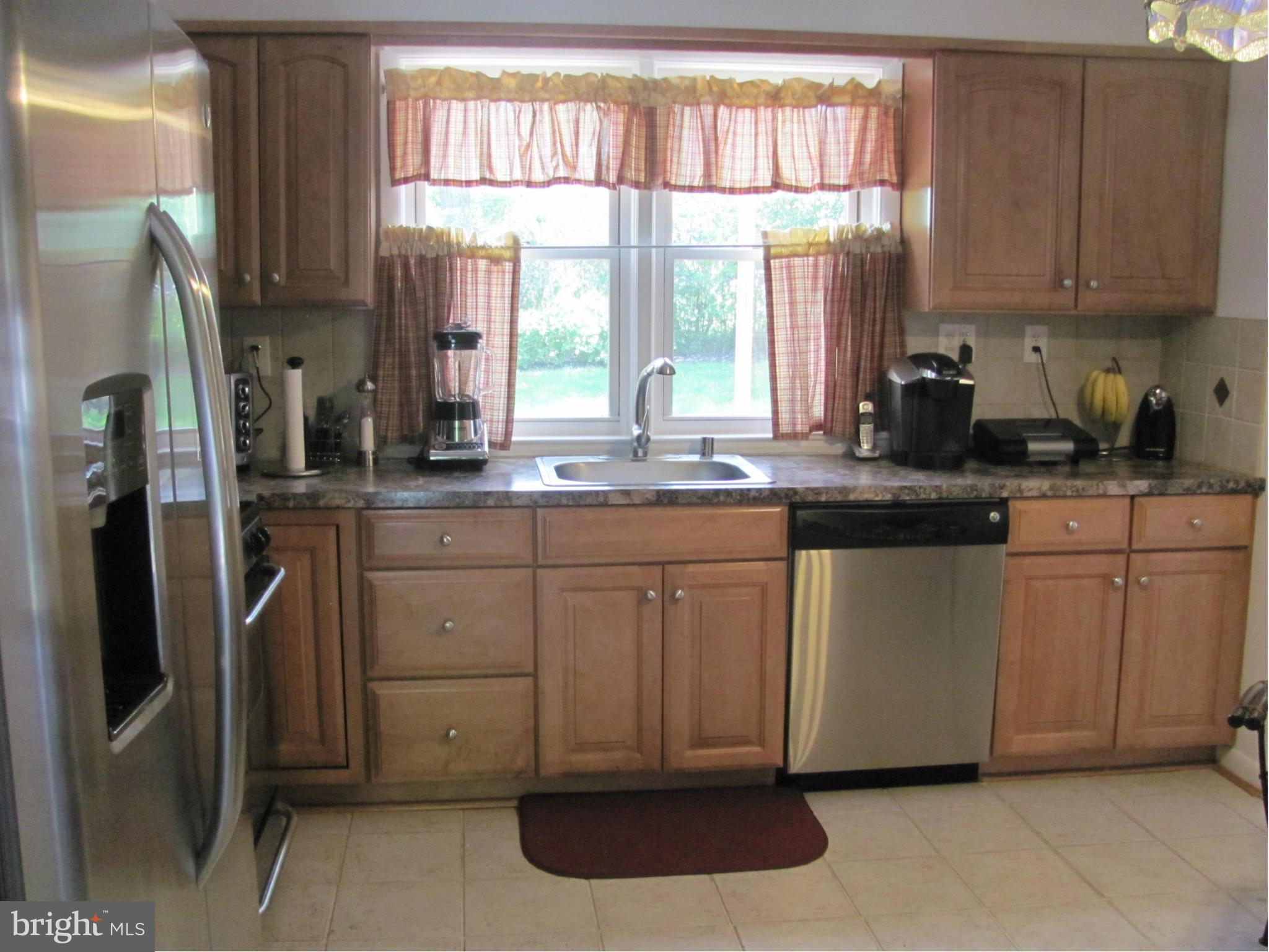 3645 Langrehr Road Baltimore, MD 21244 - Photo 9 of 25 a kitchen with stainless steel appliances granite countertop a sink a stove a refrigerator and a window