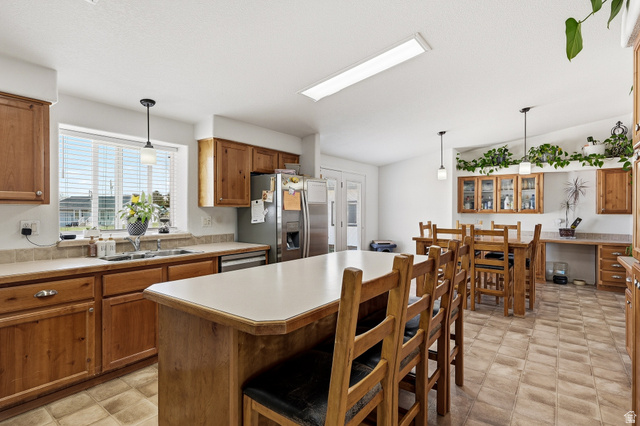 1637 East Midvalley Road Enoch, UT 84721 - Photo 9 of 48 Kitchen featuring a kitchen bar, light countertops, hanging light fixtures, wood finish cabinetry, and a kitchen island