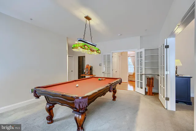 a kitchen with stainless steel appliances granite countertop a stove a sink a refrigerator a dining table and chairs