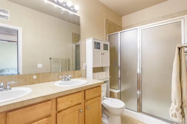 a bathroom with a granite countertop sink toilet and shower