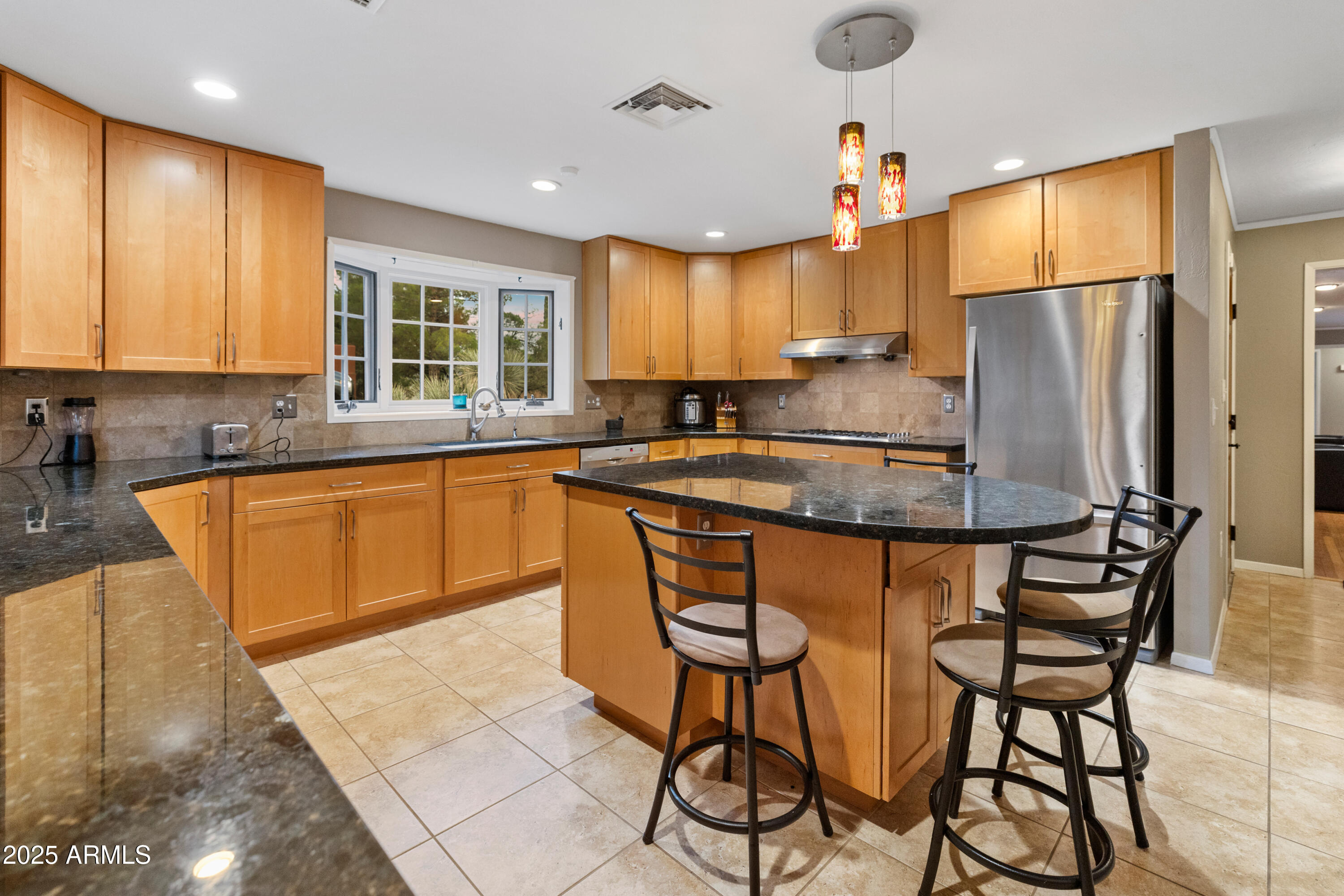 195 Courthouse Butte Road Sedona, AZ 86351 - Photo 12 of 31 a kitchen with stainless steel appliances granite countertop a sink a stove a refrigerator cabinets and a dining table with wooden floor