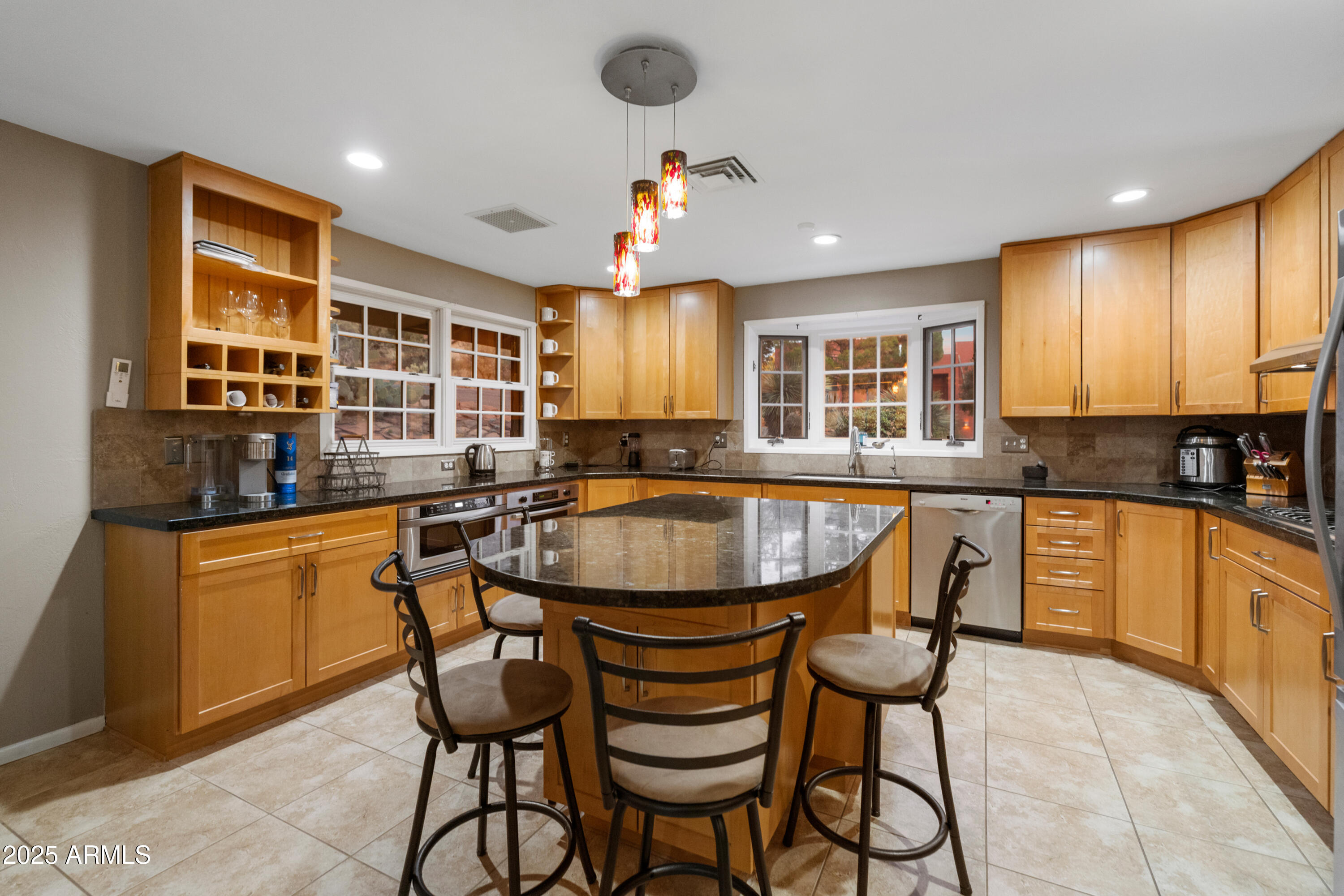 195 Courthouse Butte Road Sedona, AZ 86351 - Photo 15 of 31 a kitchen with granite countertop wooden cabinets a dining table and chairs