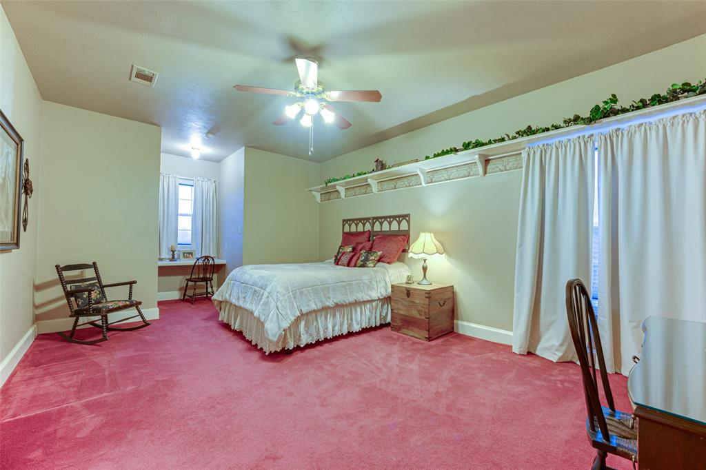 707 Cullins Road Rockwall, TX 75032 - Photo 19 of 35 a bedroom with a bed and a chandelier