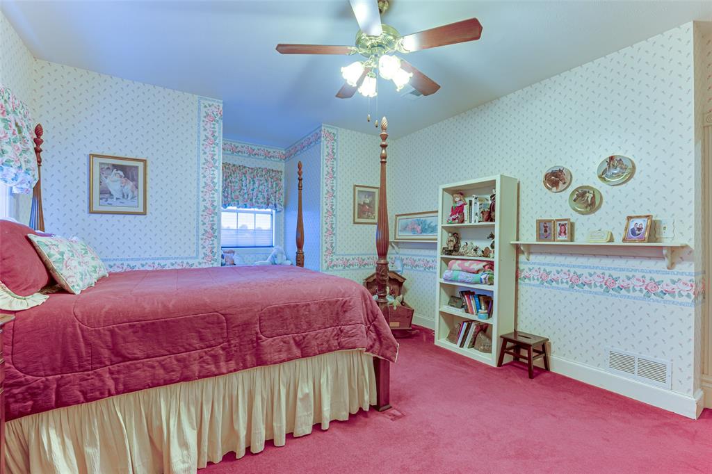 707 Cullins Road Rockwall, TX 75032 - Photo 22 of 35 a bedroom with a bed and a book shelf