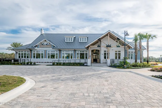 a front view of a house with a yard and potted plants