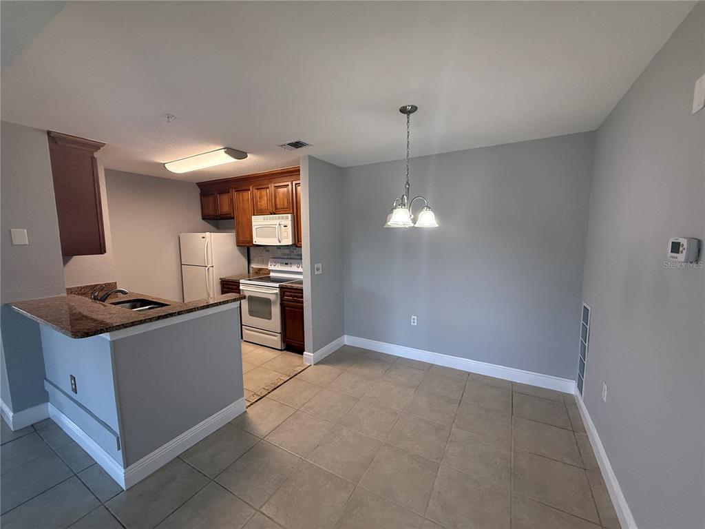 8932 Manor Loop, Unit 205 Lakewood Ranch, FL 34202 - Photo 15 of 15 a kitchen with stainless steel appliances granite countertop a sink and a stove