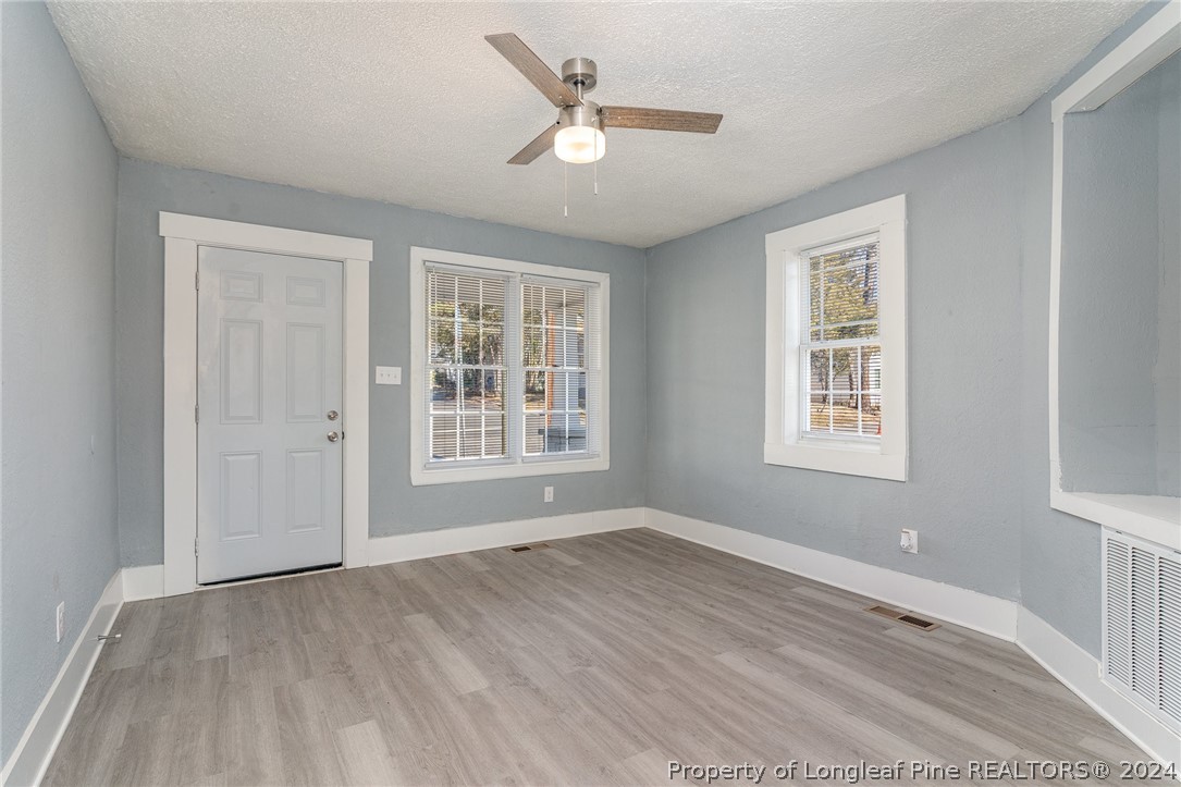 1218 Boyer Street Raleigh, NC 27610 - Photo 3 of 12 an empty room with wooden floor and windows