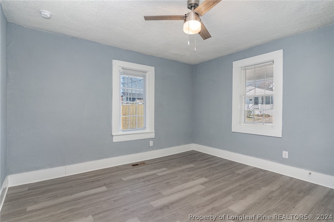 1218 Boyer Street Raleigh, NC 27610 - Photo 5 of 12 a view of an empty room with wooden floor and a window