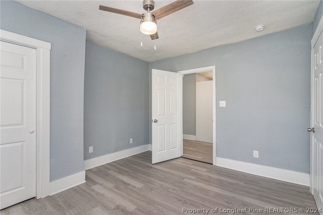 1218 Boyer Street Raleigh, NC 27610 - Photo 8 of 12 an empty room with wooden floor and ceiling fan