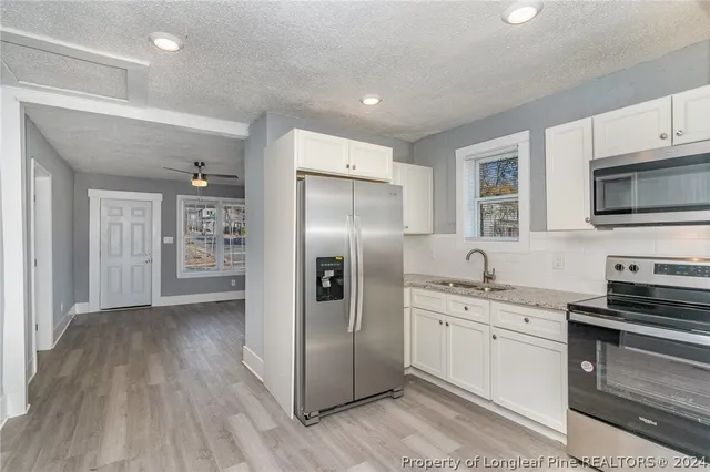 a kitchen with a sink stainless steel appliances and cabinets