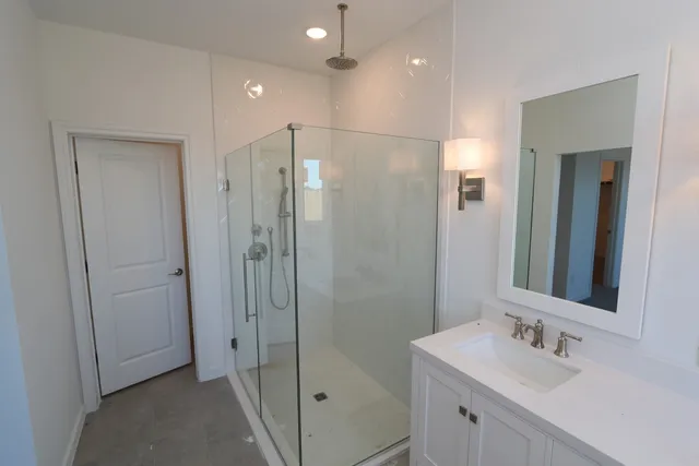 a bathroom with a shower sink and mirror