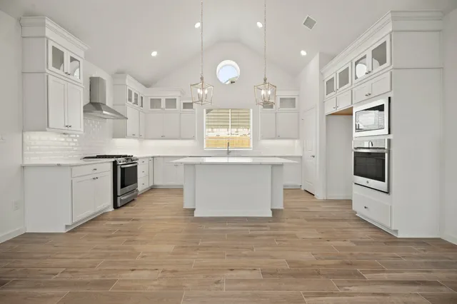 a kitchen with kitchen island a sink stainless steel appliances and cabinets