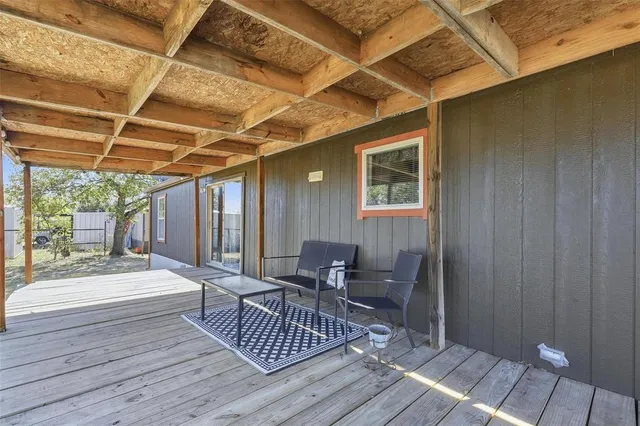 a view of a couches and table in deck with wooden floor