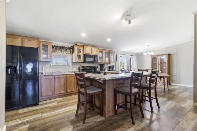 a kitchen with stainless steel appliances kitchen island granite countertop a dining table chairs and granite counter tops