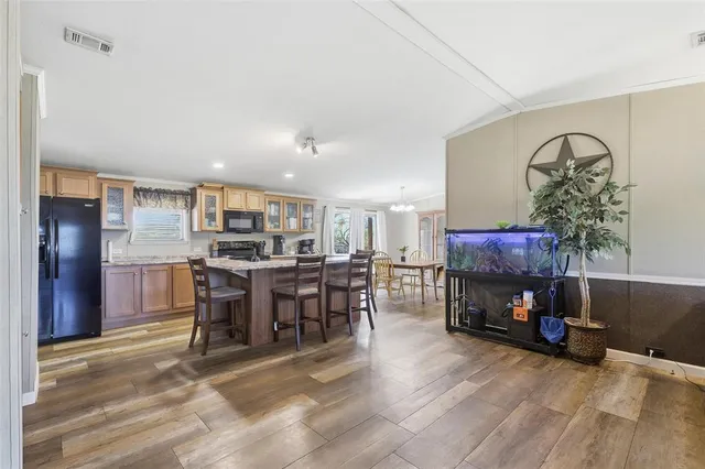 a living room with furniture a fireplace and a dining table with wooden floor