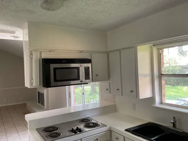 a kitchen with stainless steel appliances a stove and a microwave
