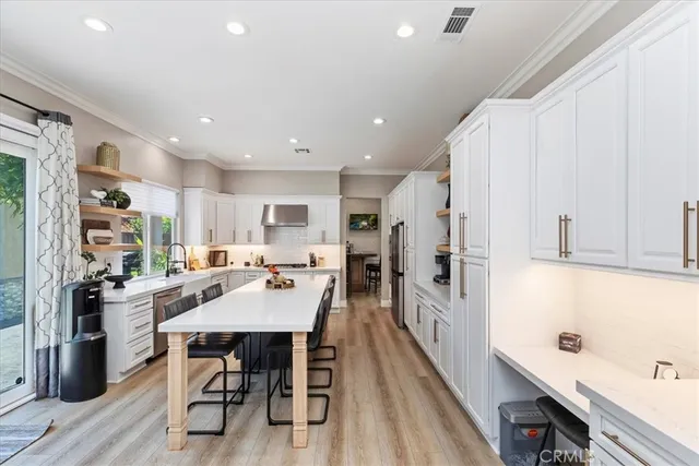 a kitchen with a refrigerator a stove a sink and a refrigerator with wooden floor