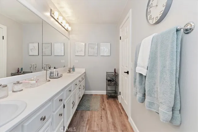a bathroom with a double vanity sink mirror and bathtub